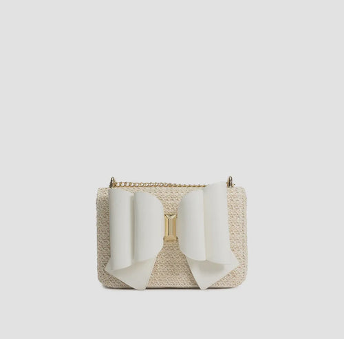 Bag is a light beige, woven straw-like material with a white accent bow on the front and  a crossbody chain.