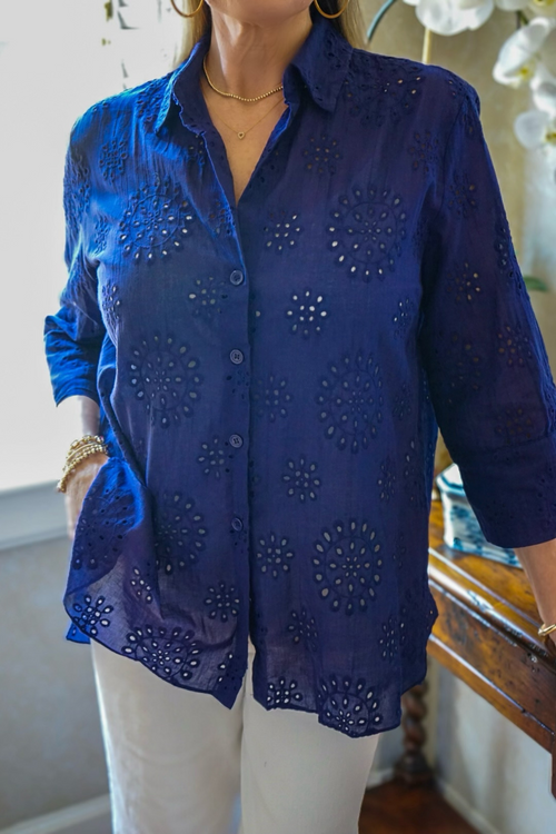 Model is wearing a navy, cotton, eyelet button down blouse