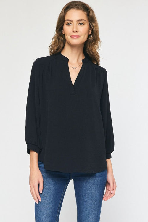 Model is wearing a black 3/4" v-neck popover blouse