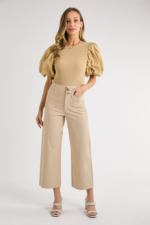 Model is wearing taupe front patch pocket dress pants with stretch construction