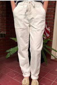 Model is wearing Judy Blue white drawstring denim pants with waist self-tie and functional patch pockets.