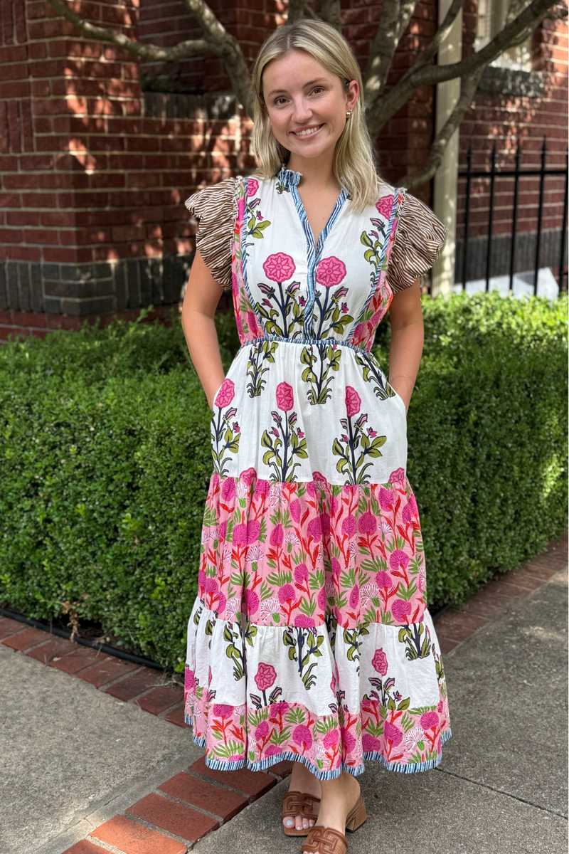 Model is wearing a boho inspired midi dress by THML in a white, pink and green floral print.
