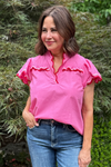 Model is wearing a hot pink top with pink and red piping along the neckline and sleeves.