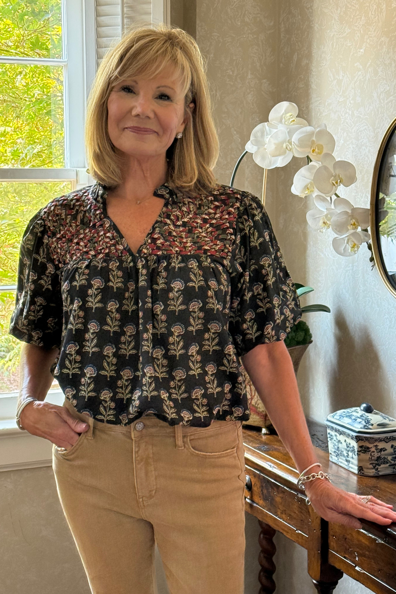 Model is wearing a chocolate brown boho floral motif top with woven yoke