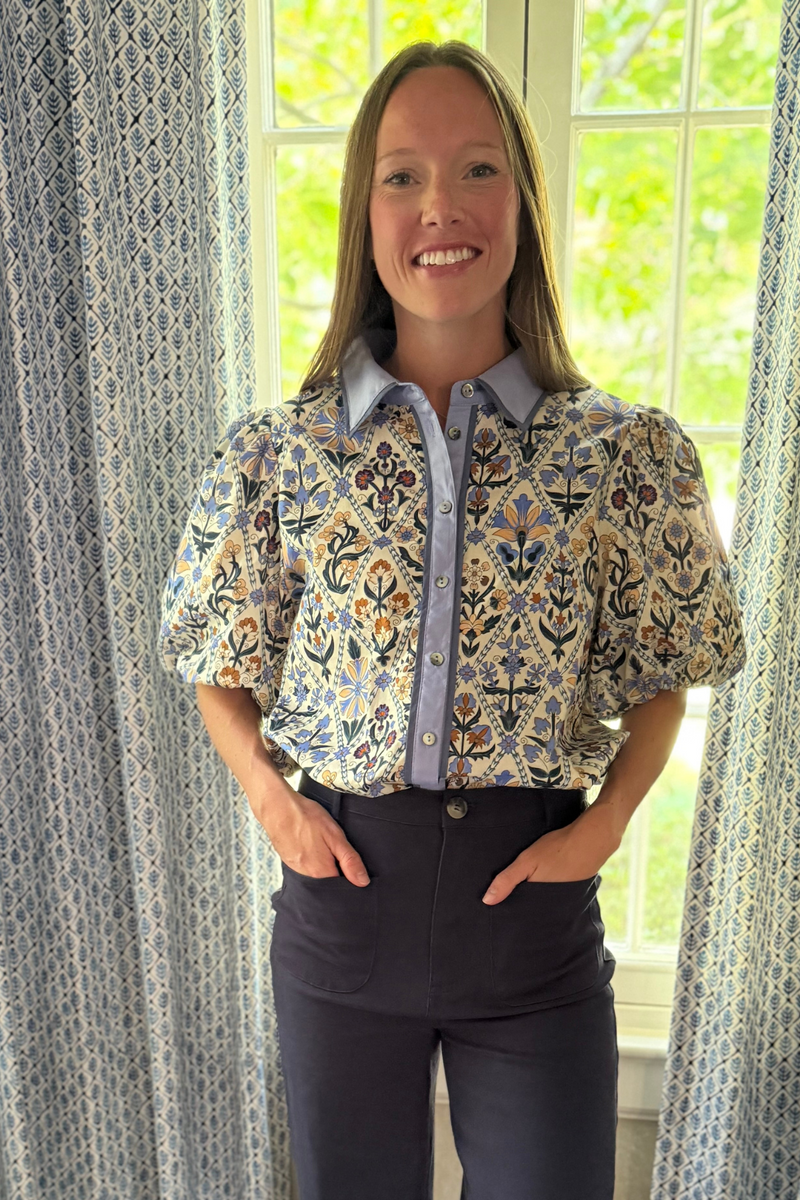 Model is wearing a 100% cotton botanical print button down top with blue collar and placket accent.