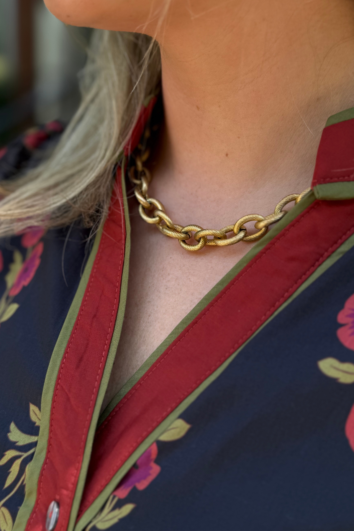 Model is wearing a chunky gold chain necklace