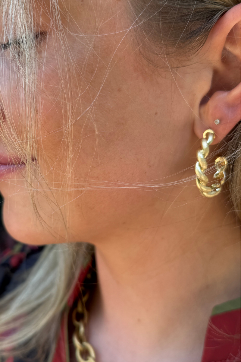 Model is wearing a medium size twisted gold hoop