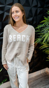 Model is wearing a sand colored, lightweight V-neck "Beach" sweater 