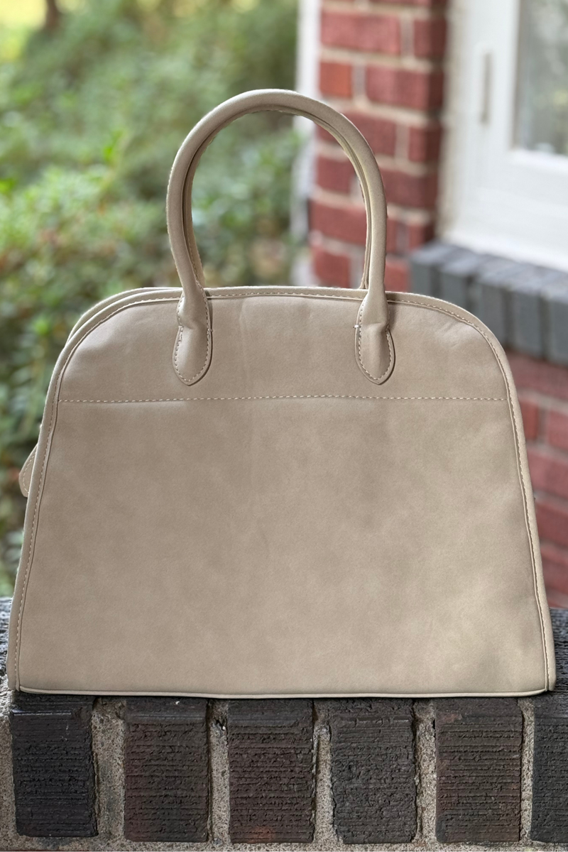 Photo is of a oat colored faux leather nubuck handbag with hand strap and detachable shoulder strap.