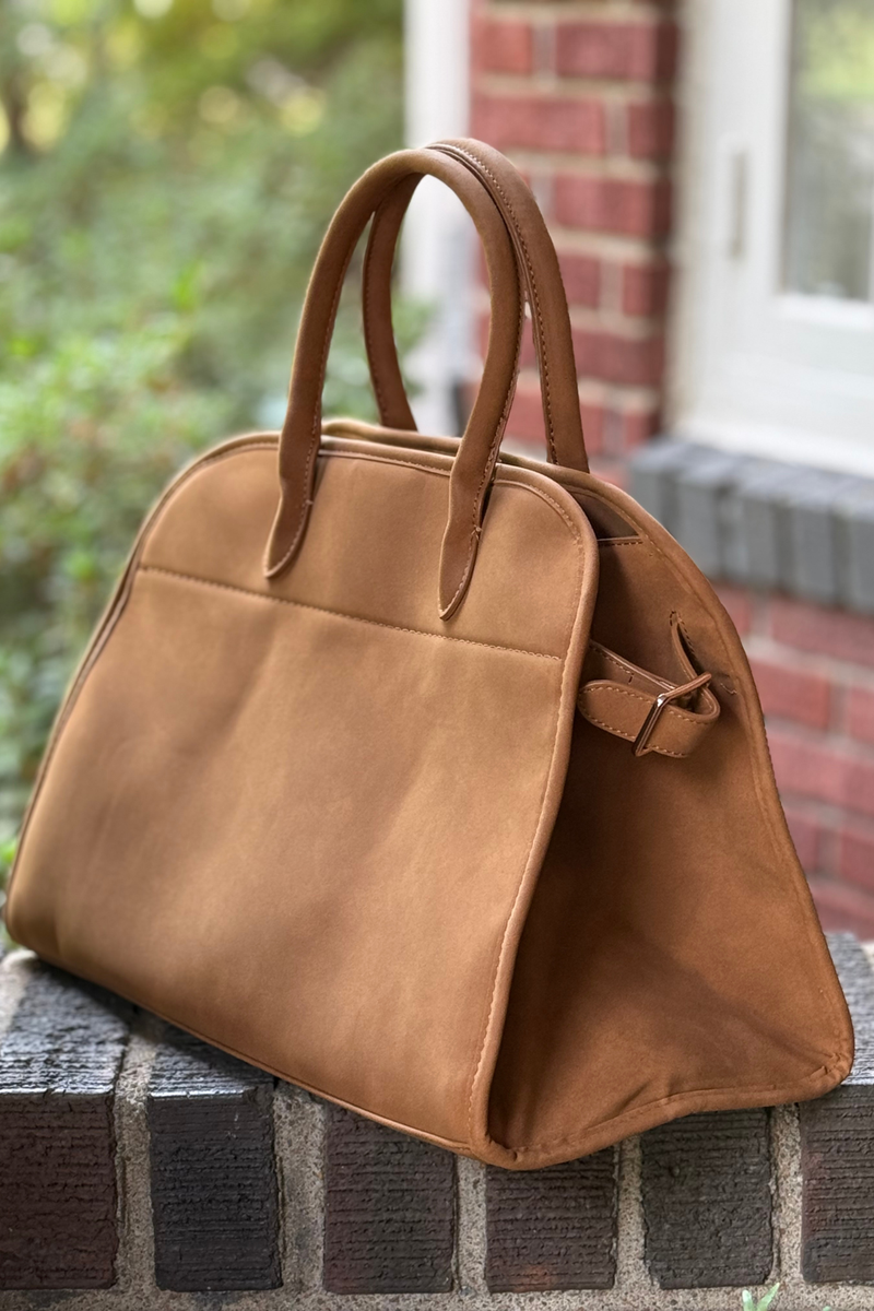 Photo is of a camel faux leather nubuck bag featuring a roomy interior and detachable crossbody strap.