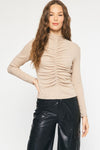 Model is wearing taupe long sleeve top with shirring detail