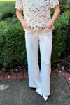 model is wearing winter white faux suede full leg pants with front and back patch pockets.