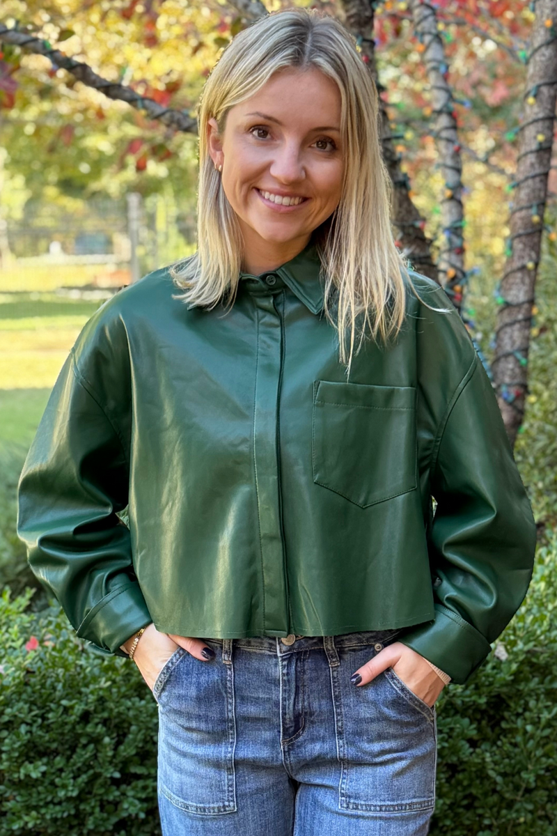 Model is wearing a kelly green leather alternative jacket with front breast patch pocket, collar and button at wrists.